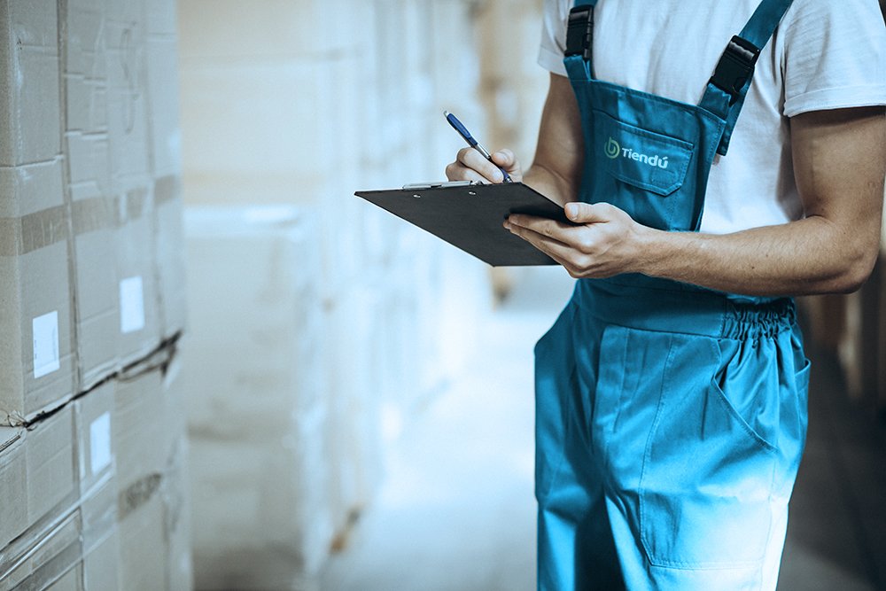 Young man working at a warehouse with boxes Tiendú